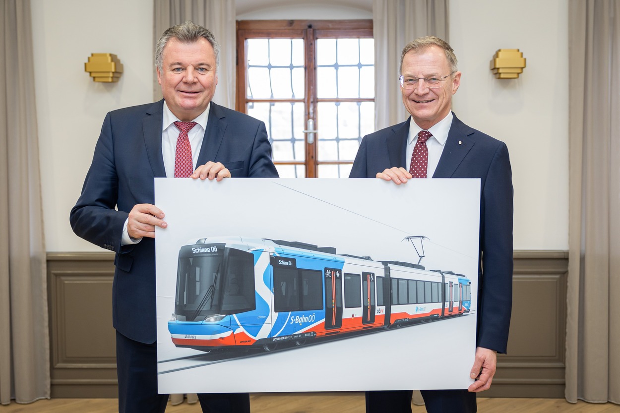 LH Stelzer und LR Steinkellner halten ein Bild der zukünftigen Regional-Stadtbahn in Händen